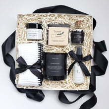 Load image into Gallery viewer, A spa gift box with a black and white color scheme which includes  charcoal facial soap, face towel, aromatherapy bath salts, moisturizing lotion, a soy candle and black and white matches in a apothecary-inspired bottle.
