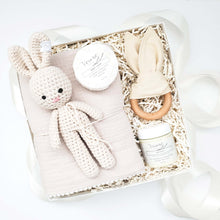 Load image into Gallery viewer, Gender neutral baby gift box from The Gift Veil featuring a toy bunny rattle, bunny ears teether, muslin swaddle blanket, gentle baby soap and baby balm.
