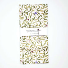 Load image into Gallery viewer, A flour sack towel handmade by Bumble and Cotton featuring a green spring leaves and blossoms print
